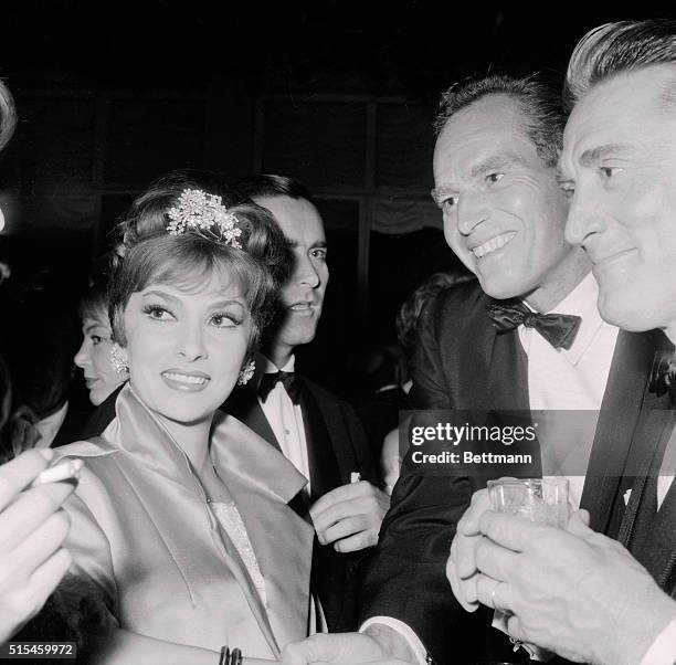 Lovely Gina Lollobrigida enjoys an animated conversation at the star-studded party which actress Elizabeth Taylor gave at the Grand Hotel in Rome....