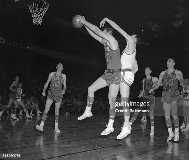 Fort Wayne's Bob Houbregs makes a bid for the basket as Philadelphia's Neil Johnston attempts to block in the pro basketball game at Madison Square...