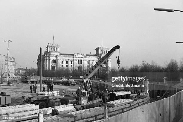 East German construction workers are occupied early November 20th here, atop the new wall in front of the Brandenburg Gate. Several thousand East...