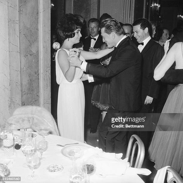 Kirk Douglas kisses actress Elsa Martinelli during the big party at the Grand Hotel in Rome, Oct. 14th, given by Elizabeth Taylor in Douglas' honor....