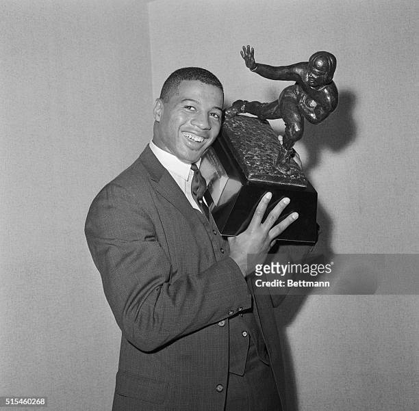 Winner of Heisman Trophy. New York, New York: Syracuse University halfback, Ernie Davis, proudly holds the 1961 Heisman Trophy which he was awarded...