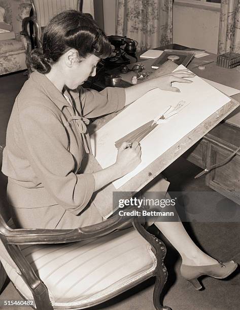 Picture shows Paramount dress designer, Edith Head shown here sketching the details for her latest project. Undated photo circa 1940s.
