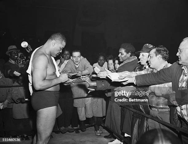 Joe Louis is shown as autograph hunters converged on him after he defeated Don "Cowboy Rocky" Lee in his debut tonight as a pro wrestler.
