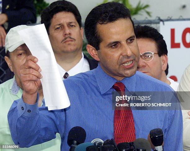 Manny Diaz an attorney of the Elian Gonzalez's Miami relatives shows legal documents during a press conference in front of their home in Little...