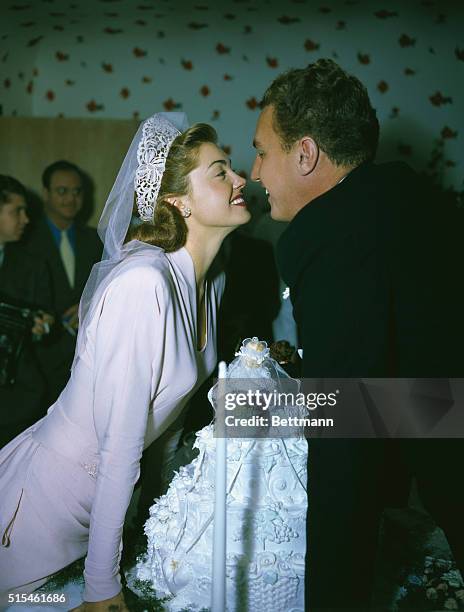 Ben Gage and Esther Williams are shown gazing at each other over their wedding cake after their wedding ceremony in Westwood Hills Congregational...