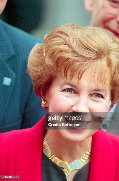 Raisa Gorbachev, in bright red, smiles at sidewalk well-wishers assembled outside the Georgetown home of Pamela Harriman, widow of Averell Harriman,...