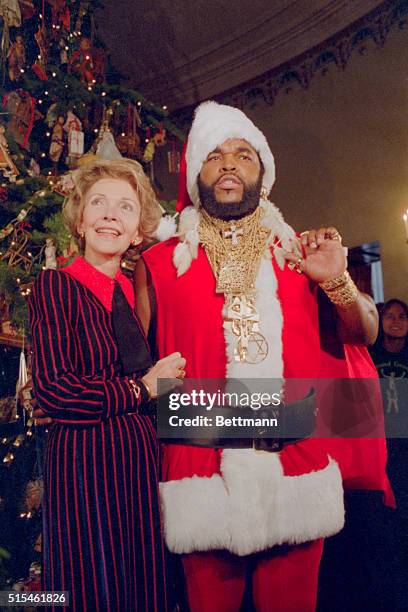 Washington, D.C.: Mr. T, of the television show the A-Team, poses as Santa Claus to help First Lady Nancy Reagan unveil the White House Christmas...