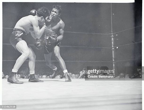 Robby Tops LaMotta in Garden Feature. Manhattan, New York, New York: Jake LaMotta, rugged Bronx middleweight, covers up under a barrage of blows by...