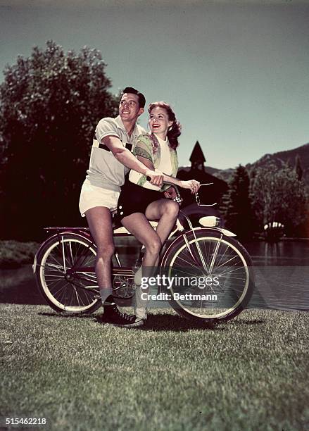 Rhonda Fleming vacationing at Sun Valley, following her latest starring role in Crosswinds, is shown as she hitches a ride on a bicycle of Keith...