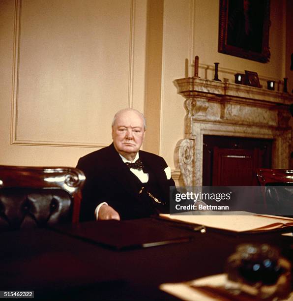 Sir Winston Churchill, Britain's Prime Minister, seated at his desk on his 80th birthday.