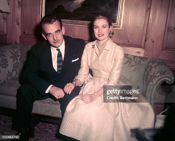 Philadelphia, PA: Prince Rainier III of Monaco and lovely Grace Kelly, reigning "Queen" of the American screen, pose for photographers at the home of...