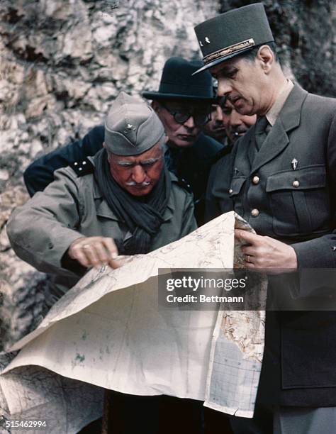 Photo shows General Charles de Gaulle looking over a map. Undated.