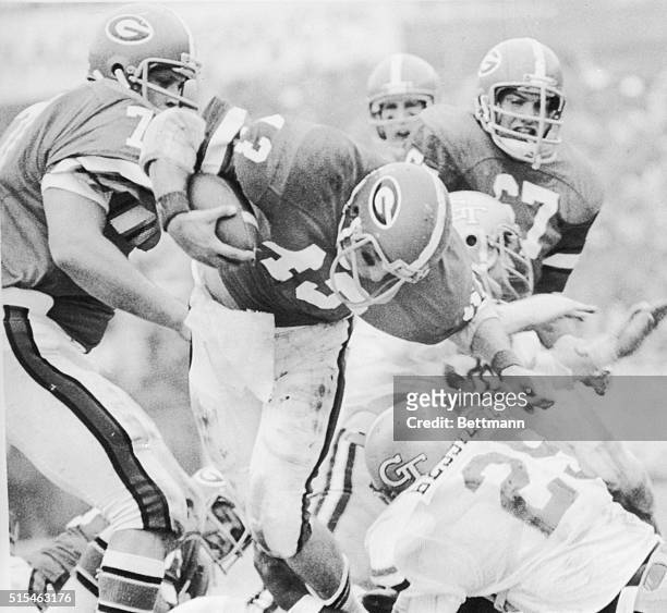 University of Georgia's Al Pollard moves through a hole created by Mike Wilson and Joel Parrish but is stopped by Tech's Don Bessillieu during 1st...