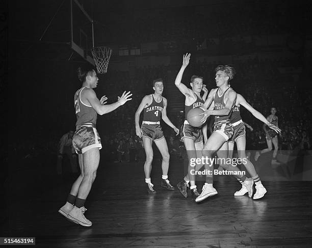 Arnold Ferrin of Utah manages to slip the ball to teammate was Misaka as Aud Brindley of Dartmouth makes valiant attempt at blocking the play. Action...