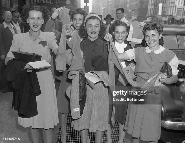 Women showing nylon stockings they bought at a hosiery shop on 6th avenue in New York City.