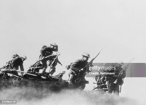 More Canadians step over...Out of the trenches and into the enemy's range go these Canadian troops, ready for combat and scornful of the bullets and...