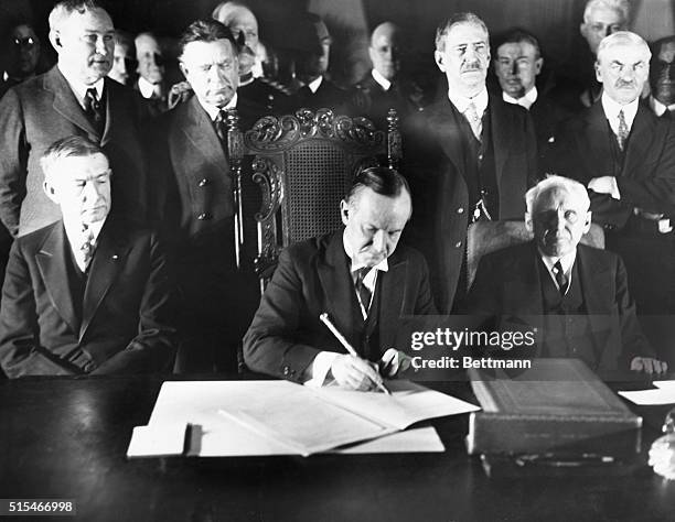 Washington, D. C.: Coolidge Signs Kellogg Peace Pact. President Coolidge in center signing the Kellogg Peace Pact, as Vice President Dawes and Frank...