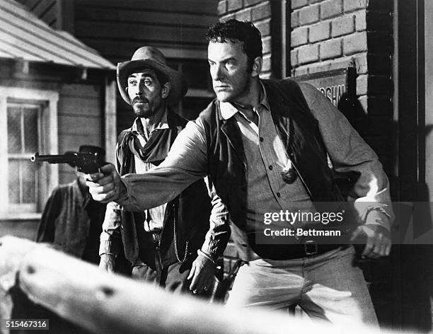 Undated television still from CBS series Gunsmoke, with Ken Curtis and James Arness. Shows Arness aiming gun in the episode entitled The Raid - Part...