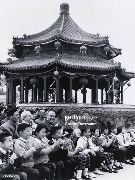 New Zealand Prime Minister Robert Muldoon and his wife, Thea, clap hands while Chinese Foreign Minister Chiao Kuan-hua chortles away as they watch a...