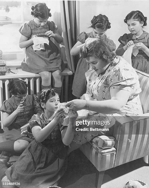 The Five Are Ten. Like any other girls of 10, the Quints are fascinated by embroidery. Cecile is being straightened out by Mrs. Dionne while Yvonne...