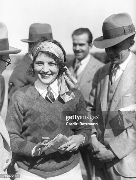 Ruth Elder, an American aviatrix prominent during the 1920s. Here, ca. 1920, she smiles with a crowd around her. Later, in 1929, she was noted as...