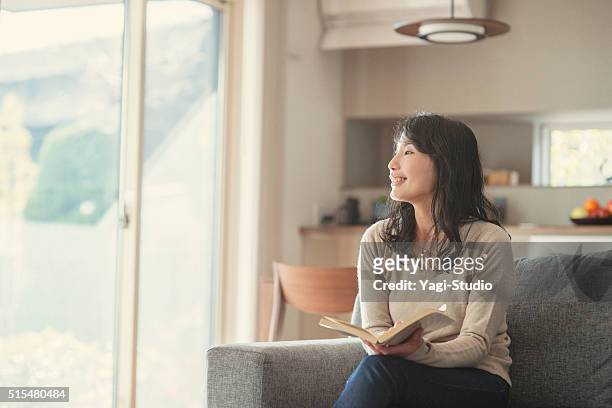 女性が良い自宅での時間 - home interiors ストックフォトと画像