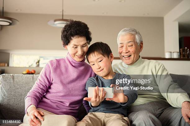 grandson taking a family photo with smartphone - grandpa son stock pictures, royalty-free photos & images