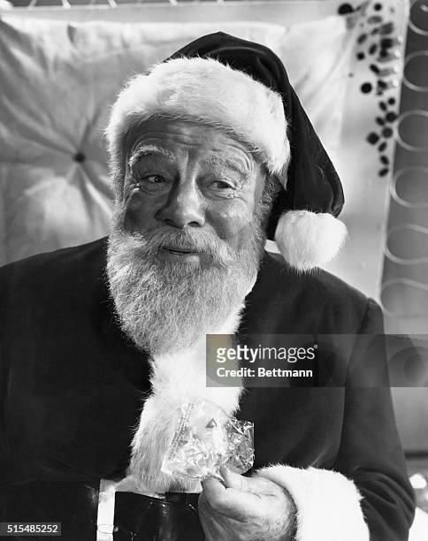 Kris Kringle passes out candy to the kids at Macy's where he plays Santa Claus. Miracle On 34th street, a 20th century Fox Production.
