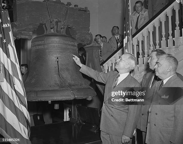 President Harry Truman examining the historic Liberty Bell in Independence Hall.