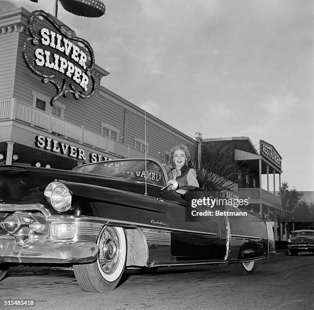 Christine Jorgensen poses in the driver's seat of a Cadillac, parked in front of of the Silver Slipper, a casino and nightclub located in Paradise,...