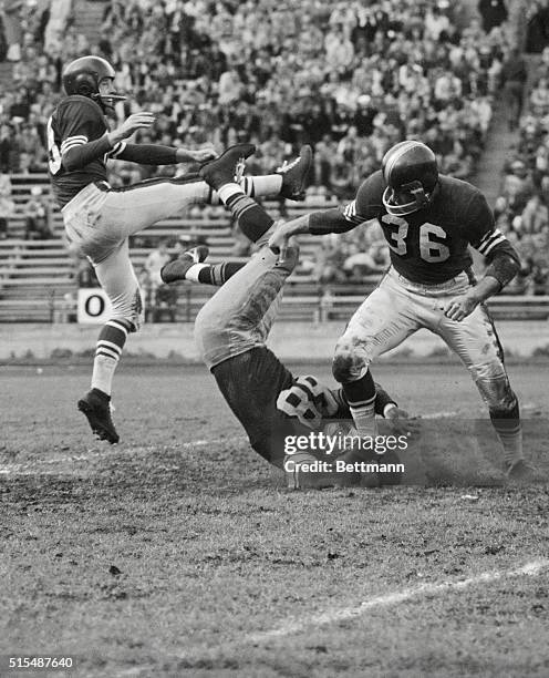 Green Bay Packer guard Len Szafaryn, , ends up heads down as he tries to block a punt by 49er halfback Bobby Luna, , during their pro clash at Kezar...