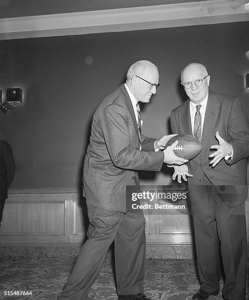 George Halas , owner of the Chicago Bears, hands over a football as well as head coaching job to John L. "Paddy" Driscoll appointed by Halas, who is...