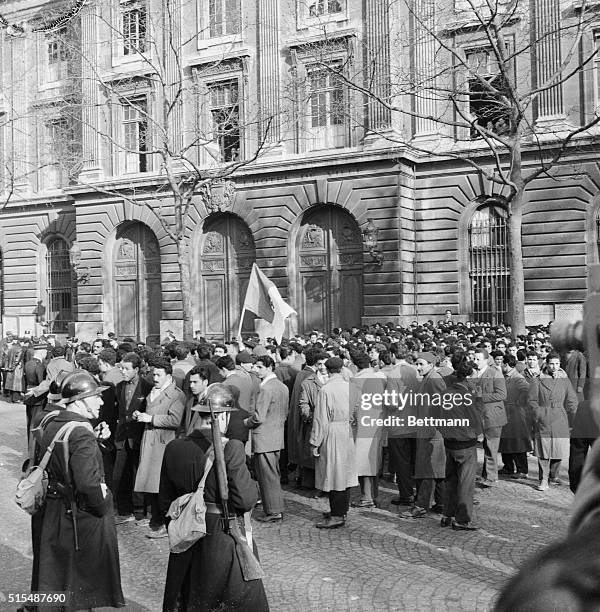 Algerians, part of a mob of 10,000 who staged a protest march on the French National Assembly here, wave a Nationalist flag as police block them at...