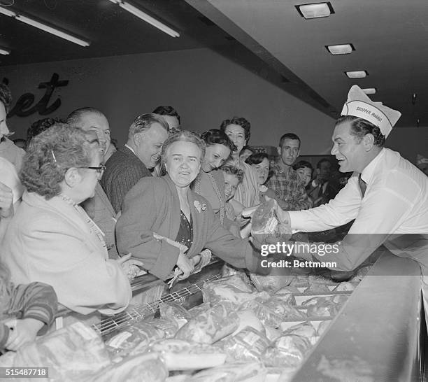 Academy Award nominee Ernest Borgnine tries hard to sell a woman a roast, but she seems more intent on having her picture taken, as the actor lends a...