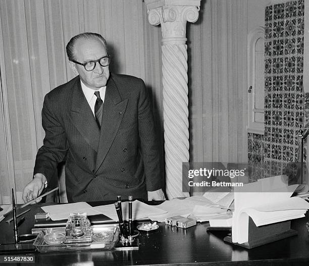 French Premier Guy Mollet is shown at his desk at his headquarters in the Summer Palace in Algiers. The Premioer is consulting with North African...