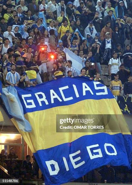 Fans of Argentina's Boca Juniors wave a flag in honor of Argentine soccer star Diego Armando Maradona before a soccer match in Mexico City 07 June,...