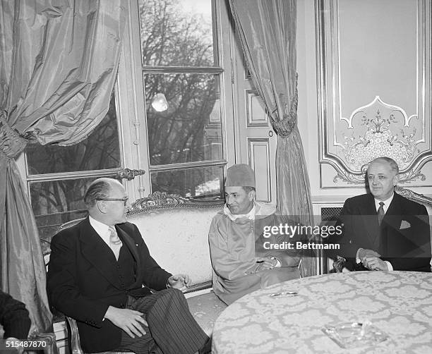 King Muhammad V of Morocco sits with French Prime Minister Guy Mollet and French Foreign Minister Christian Pineau. The King was in Paris to begin...