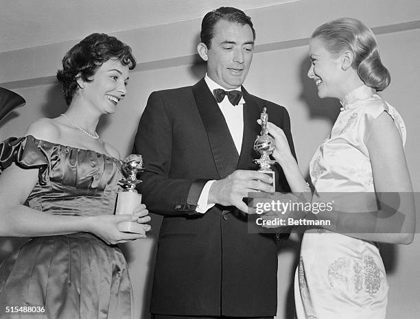 Actress Grace Kelly smiles as she receives from actor Gregory Peck the Henrietta Award given her as the "favorite actress" of the Hollywood Foreign...