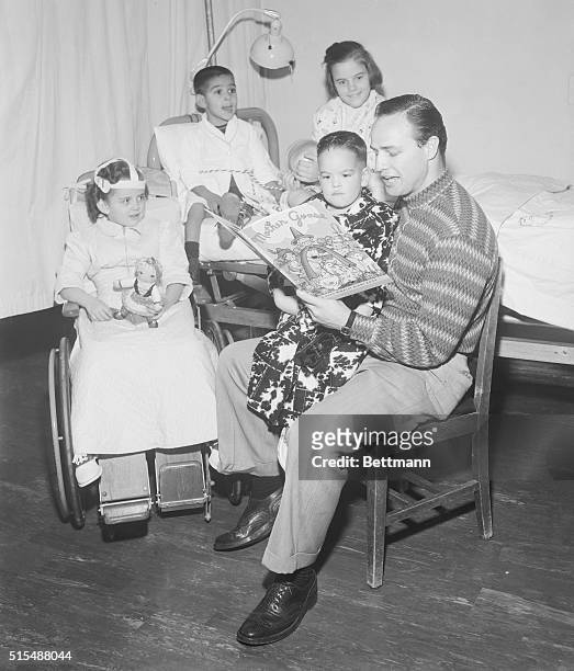 Academy Award winning actor Marlon Brando takes time out from screen scripts to read some passages from Mother Goose to tiny polio patients at the...
