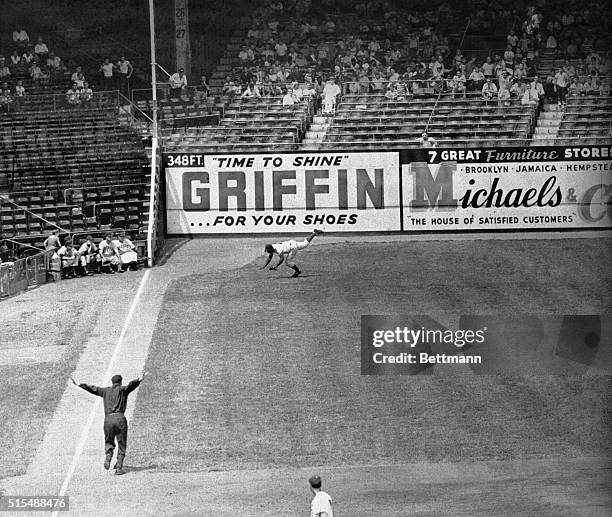 Jackie Robinson, Dodgers left fielder falls in a futile inning of this game with the Cubs at Ebbets Field. Jackson's hit was good for a trip...