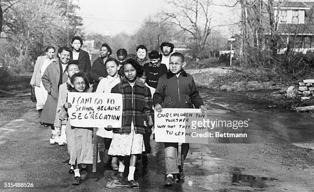 Following the US Supreme Court's order for immediate integration , sixteen Black children, carrying signs and accompanied by four mothers, walk to...