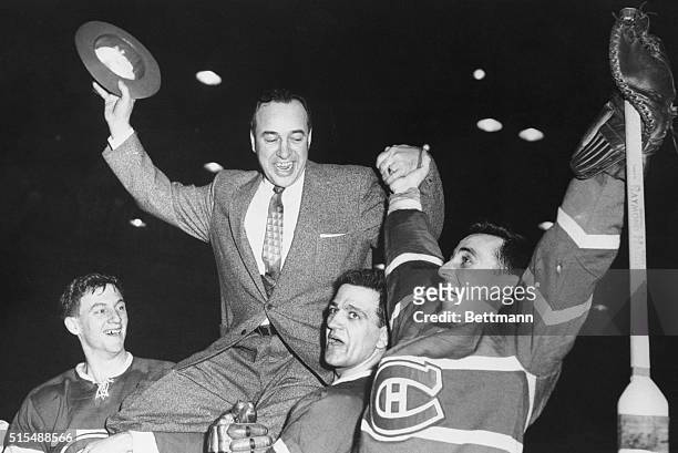 Dickie Moore, Bernie Geoffrion and goalie Jacques Plante chair coach Toe Blake after Montreal Canadiens beat Detroit Red Wings 3-1 to win Stanley...