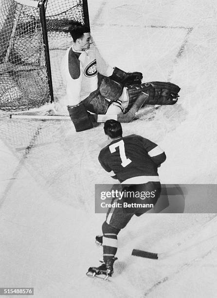 Montreal goalie Jacques Plante falls to the ice as he kicks away a shot by Detroit's Ted Lindsay during play in the first period of the...