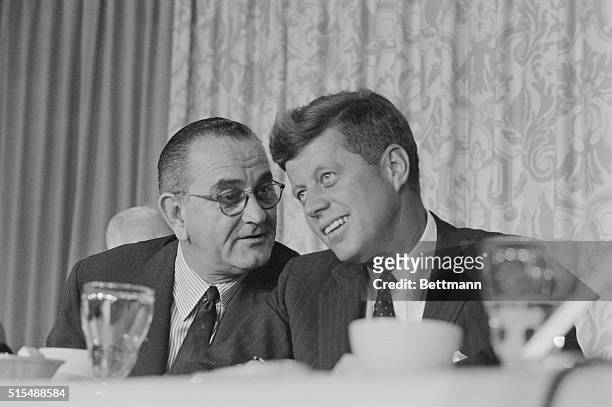 John F. Kennedy smiles as Lyndon Johnson speaks to him at breakfast during the time of the Democratic convention in Los Angeles.