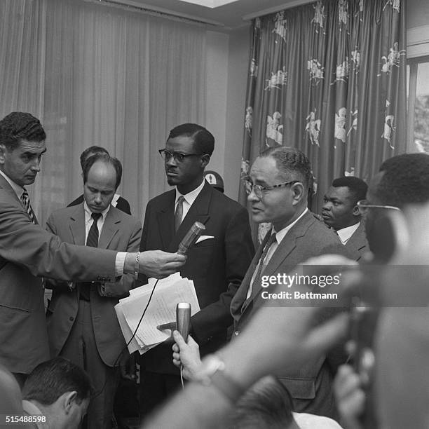 Congo Premier Patrice Lumumba listens as United Nations representative Dr. Ralph Bunche answers a reporter's question during a press conference at...