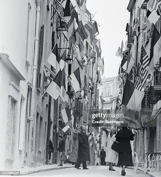 And Monaco flags fly by the score from buildings along a narrow street in the principality of Prince Rainier III. Practically every doorway and...