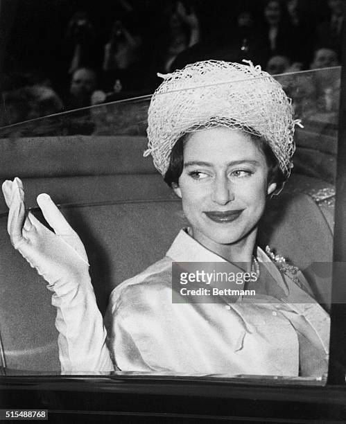 Princess Margaret waves from her coach at Buckingham Palace here May 6th as she leaves on her honeymoon with Antony Armstrong-Jones.