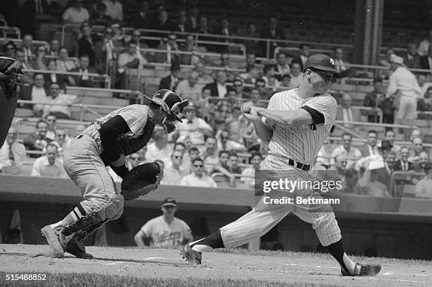 Baltimore Orioles catcher Clint Courtney uses a specially designed "Peach Basket" type mitt to catch from knuckleballer Hoyt Wilhelm as Mickey Mantle...