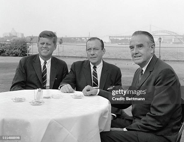 Senator John F. Kennedy, sits with new York Mayor Robert Wagner, , and former New York Governor Averell Harriman during a reception on the lawn of...