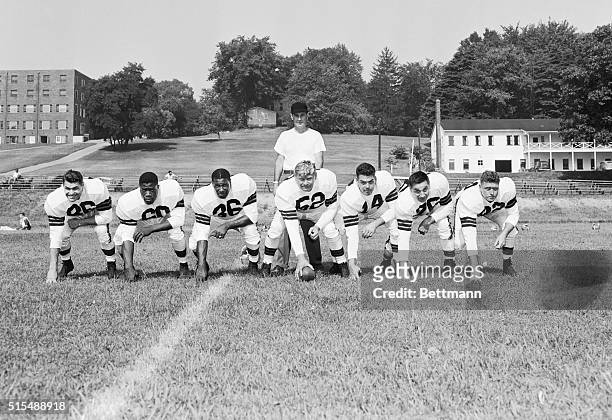 In pre-season practice, Coach Paul Brown as "quarterback" behind seven Cleveland Browns' players who have been together since the team's existence....